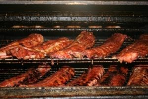 Slabs of barbecued meat on the grill at Red Rock Cafe and Back Door BBQ